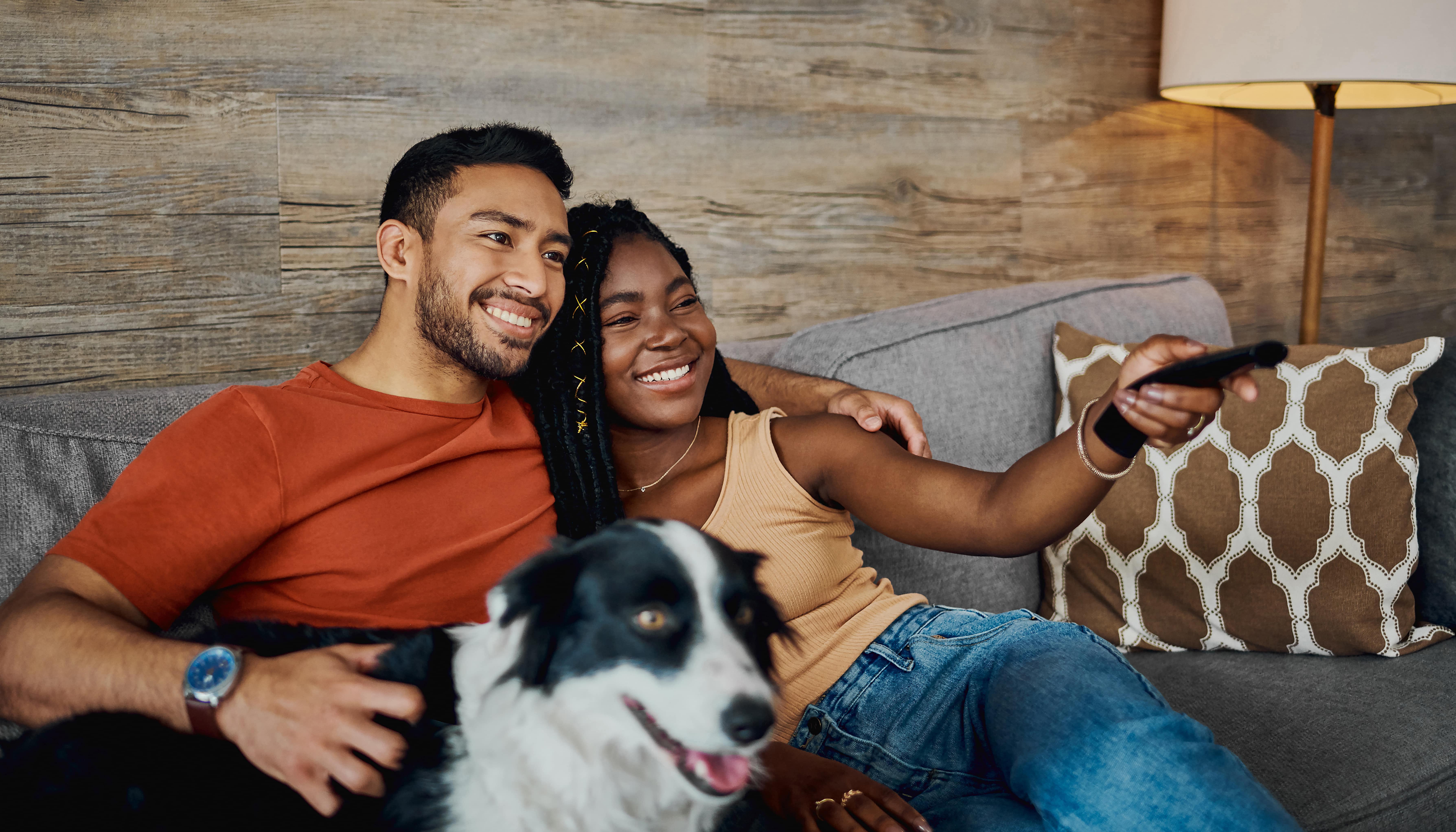 couple on the couch with their dog watching TV