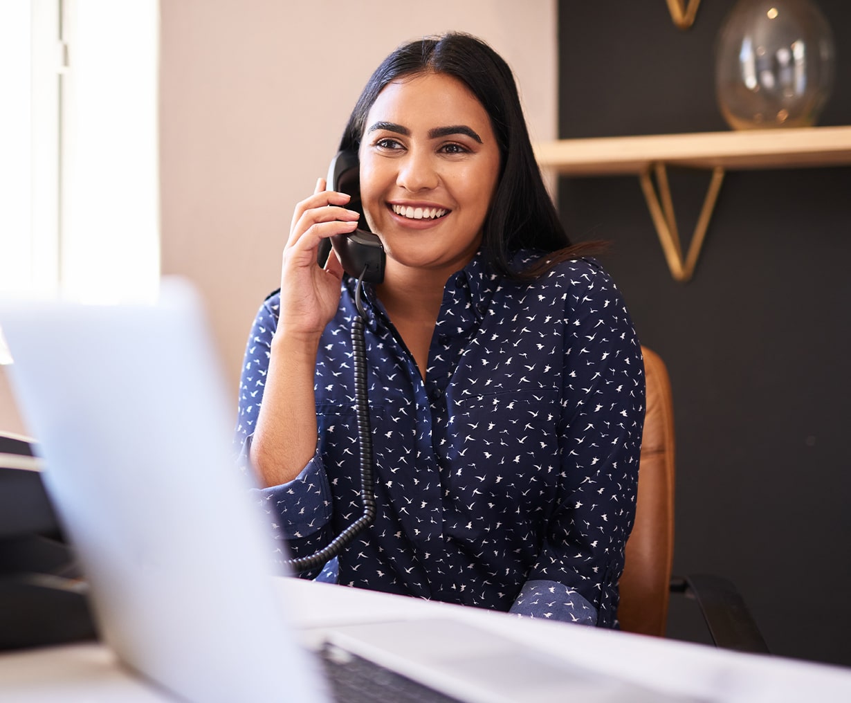 women on the phone in front of a computer at home