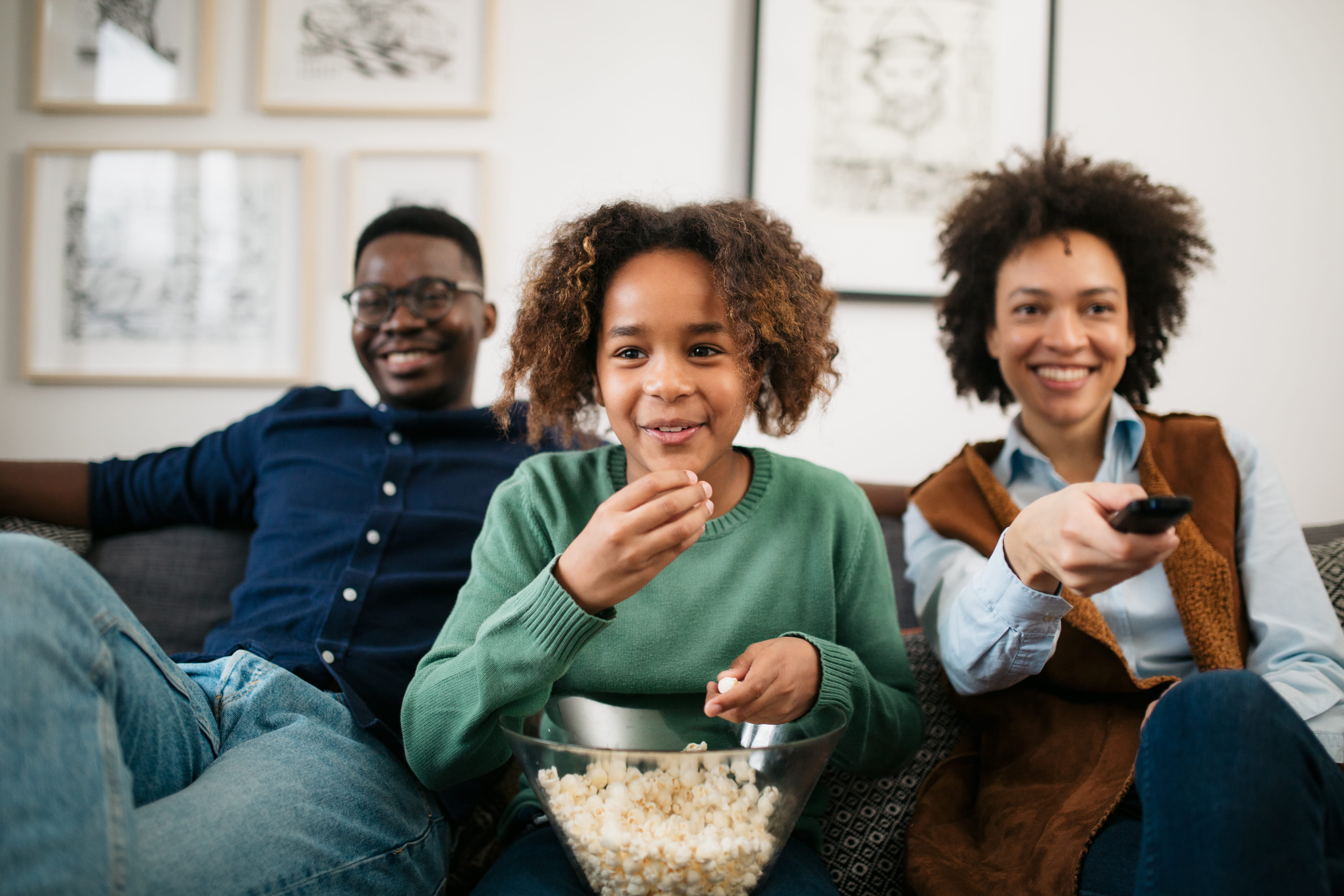 Family on couch eating popcorn